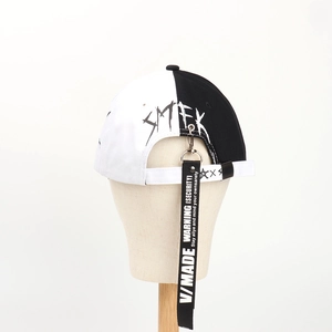 Modern black and white split baseball cap with SMFK graffiti and long ribbon charm