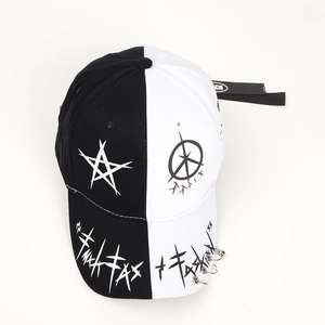 Detail of black and white baseball cap with silver rings and star graffiti pattern