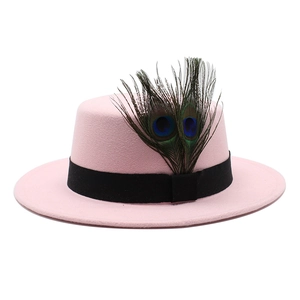 Detail of pink wool felt boater hat featuring natural peacock feathers and black ribbon