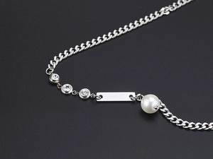 Detail of silver pearl and cuban chain necklace with sparkling cubic zirconia pendant