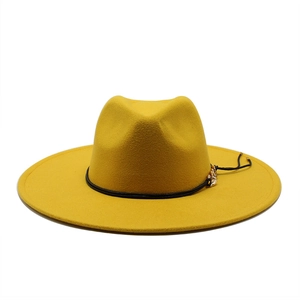 Detail of yellow wool felt fedora featuring a black band and gold leaf metal ornament