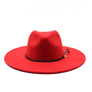 Detail of red wide-brim wool fedora hat with black leather band and gold metal accent