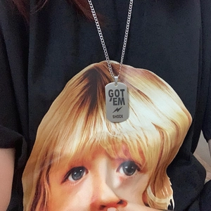 Silver military tag necklace with GOT EM SHOCK engraving worn on a black graphic t-shirt