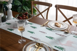 Close-up of chenille table runner with embroidered green pine trees and pink elk patterns