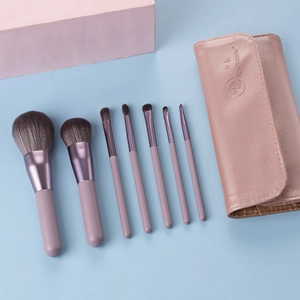 Detail of 7 mini makeup brushes with soft synthetic bristles and lilac leather travel pouch