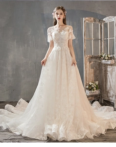 Close-up of elegant floral lace embroidery and illusion neckline on white wedding gown
