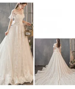 Detail of off-shoulder lace wedding dress with bow back and elegant floral embroidery