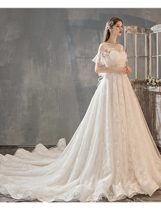 Detail of French lace embroidery and sheer neckline on a white bridal gown with train