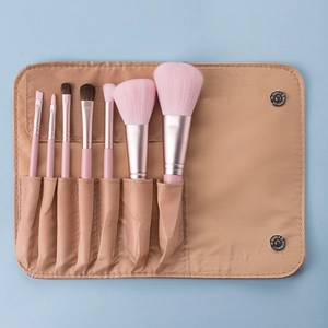 Pink 7-piece mini makeup brush set with rose gold ferrules in a beige button pouch