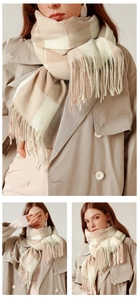 Dettaglio della sciarpa a quadri beige e rosa con frange su morbido tessuto tipo cashmere