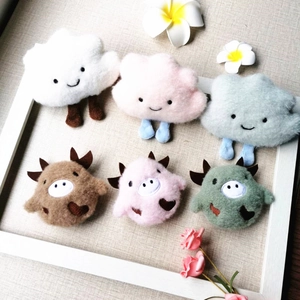 Detail shot of cute plush monster pins in cloud and cattle shapes on a wooden frame