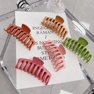 Detail view of five large matte hair claws in vibrant Morandi colors on aesthetic card