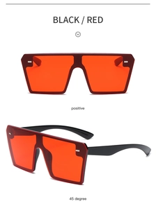 Close-up of frameless square sunglasses in black with red lenses and metal stud detail
