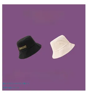 Detail of embroidered peacey logo on high-quality black and beige canvas bucket hats