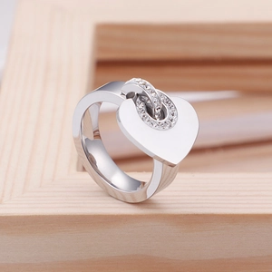 Bague cœur en argent poli avec anneau serti de pavé de diamants sur fond en bois clair