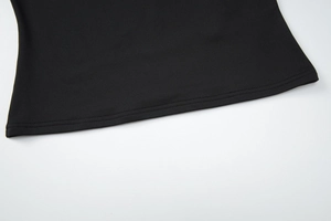 Vue détaillée de la couture à double aiguille et de l'ourlet plat sur un haut noir