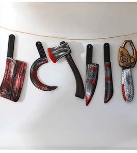 Detail of Halloween bloody plastic weapon props including chainsaw and sickle