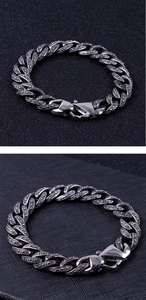 Makro-Detail des silbernen Edelstahl-Panzerarmbands mit gepunkteter Textur-Oberfläche