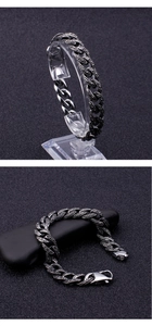 Detail eines silbernen Panzerarmbands mit Vintage-Textur auf schwarzem Steinhintergrund