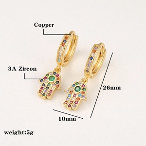 Detailed macro view of gold Hamsa Hand drop earrings with colorful 3A zircon stones