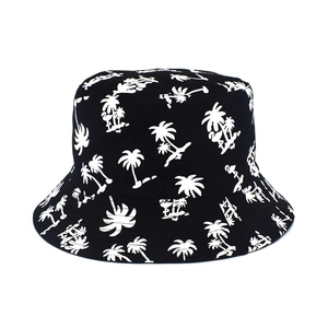 Close-up of tropical palm tree and flamingo print on black cotton bucket hat fabric
