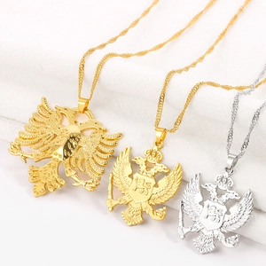 Vue détaillée des pendentifs aigle à deux têtes en or et argent avec chaînes ondulées
