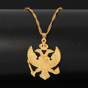 Gros plan d'un pendentif aigle à deux têtes doré avec détails de couronne héraldique