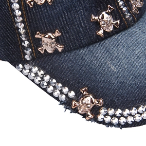 Detail of denim baseball cap with rose gold skull studs and sparkling rhinestones