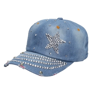 Close-up of light blue denim baseball cap with star rhinestone patterns and distressed details