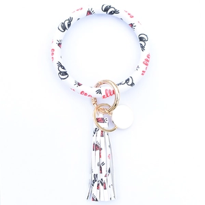 Detail of white PU leather wristlet keychain with gold metal ring and tassel charm
