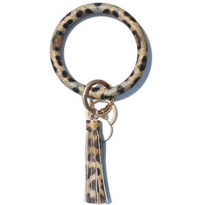 Detail view of leopard print PU leather wristlet keychain with gold ring and tassel charm