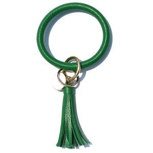 Macro shot of green faux leather wristlet keychain with gold ring and tassel detail
