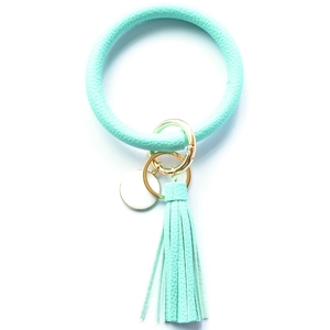 Detail of mint green leather keychain bracelet with tassel and golden metal clasp
