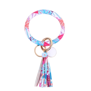 Detail of tropical leaf print PU leather bangle keychain with golden ring and tassel