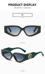 Detail of green cat-eye sunglasses with red accents and golden S logo on the temple