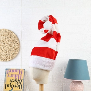 Detail of red and white striped plush Christmas elf hat with a large white pompom