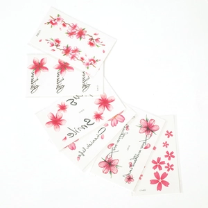 Detailed view of pink cherry blossom tattoo stickers with Smile text and floral patterns