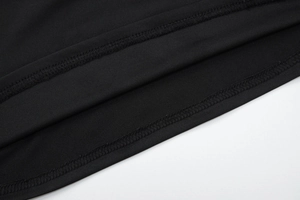 Gros plan sur l'ourlet de vêtement noir avec détails de couture à double aiguille