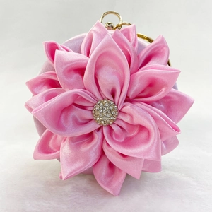 Detail of pink satin flower evening clutch bag with sparkling rhinestone center
