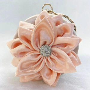Detail of peach silk petal evening bag with rhinestone flower center and round handle