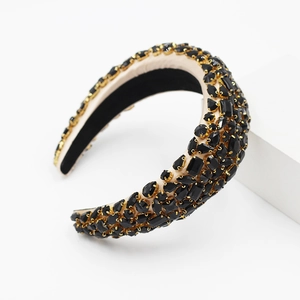 Détail d'un serre-tête baroque large avec strass noirs et sertissage en métal doré