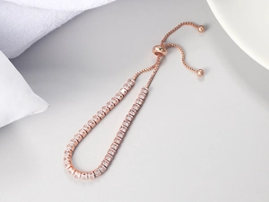 Detail of rose gold slide bracelet featuring a row of square white zircon stones
