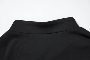 Gros plan du col montant noir en maille avec des coutures lisses et une texture fine