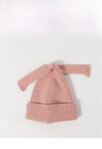 Detailed knit texture and long bow design on pink children winter beanie hat