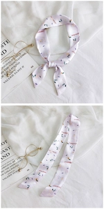 Macro detail of lavender strawberry silk scarf ribbon tied around a handbag handle