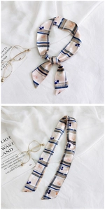 Detail of floral skinny scarf tied as a bow on a purse handle with vintage aesthetic