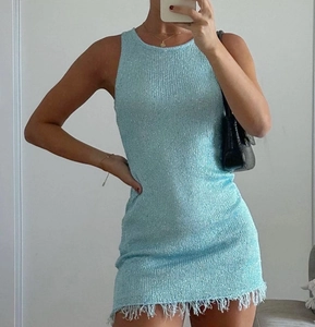 Close-up of light blue sleeveless knit dress with vertical texture and white tassel hem