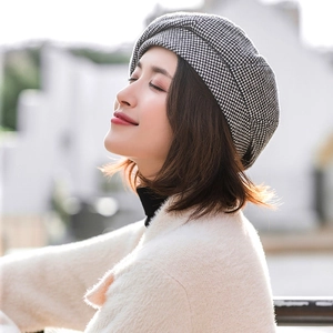 Classic black and white houndstooth beret hat for women worn in an outdoor setting