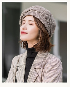 Detailed view of the brown plaid beret and matching coat texture in high quality