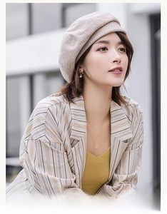 Close-up of a light brown checkered wool beret worn by a model in a stylish outfit